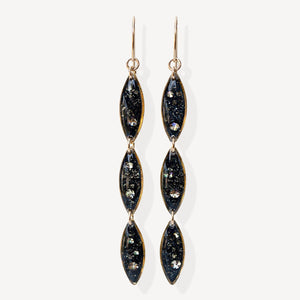 Pair of black and gold earrings on a white background