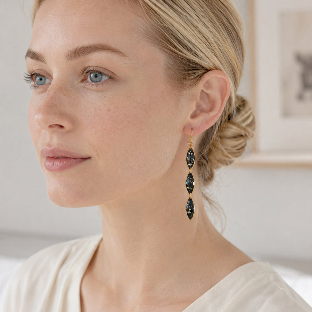 Pair of black and gold earrings on a white background