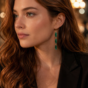 Close-up of a woman wearing green earrings with a blurred background