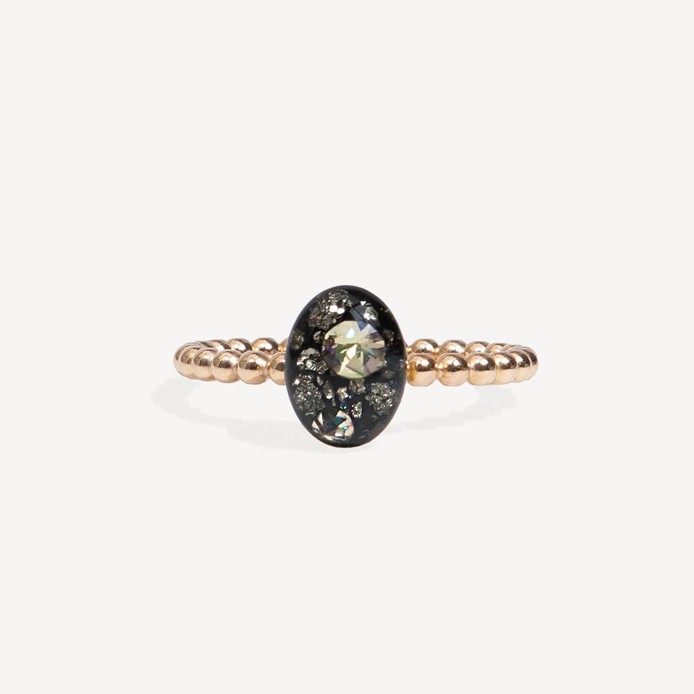 Gold ring with a black gemstone and diamonds on a white background