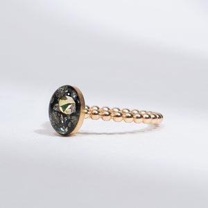 Gold ring with a gemstone on a light gray background