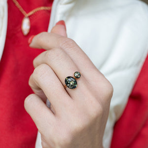 Close-up of a hand wearing a ring with a red background