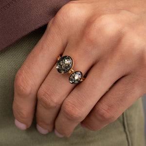 Close-up of a hand wearing two rose gold rings with gemstones.