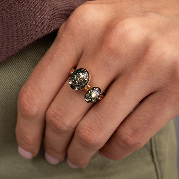 Close-up of a hand wearing two rose gold rings with gemstones.