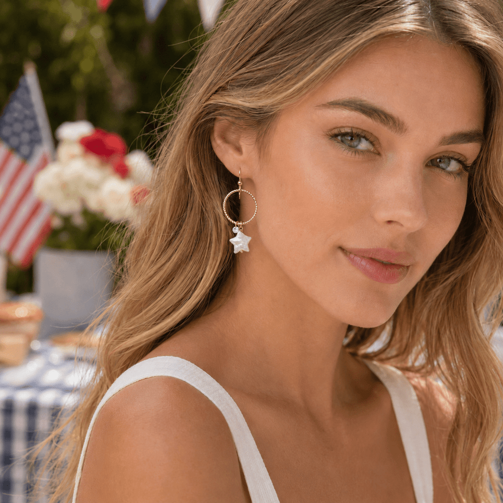 Rose gold hoop earrings with star-shaped charms on a white background