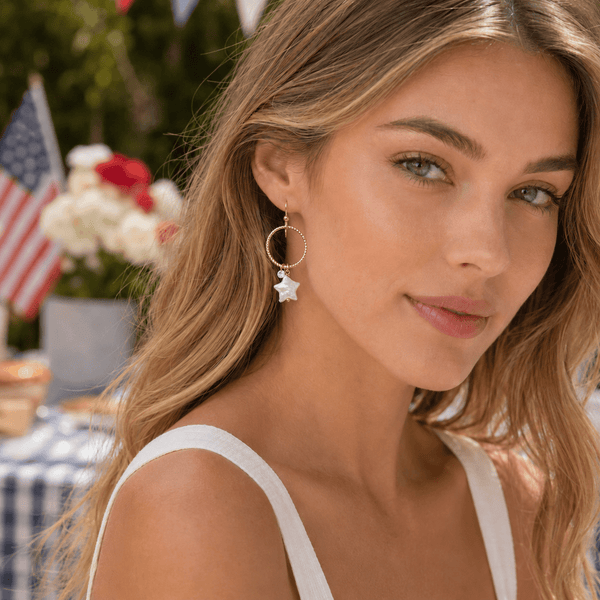 Woman wearing hoop earrings with a blurred outdoor background