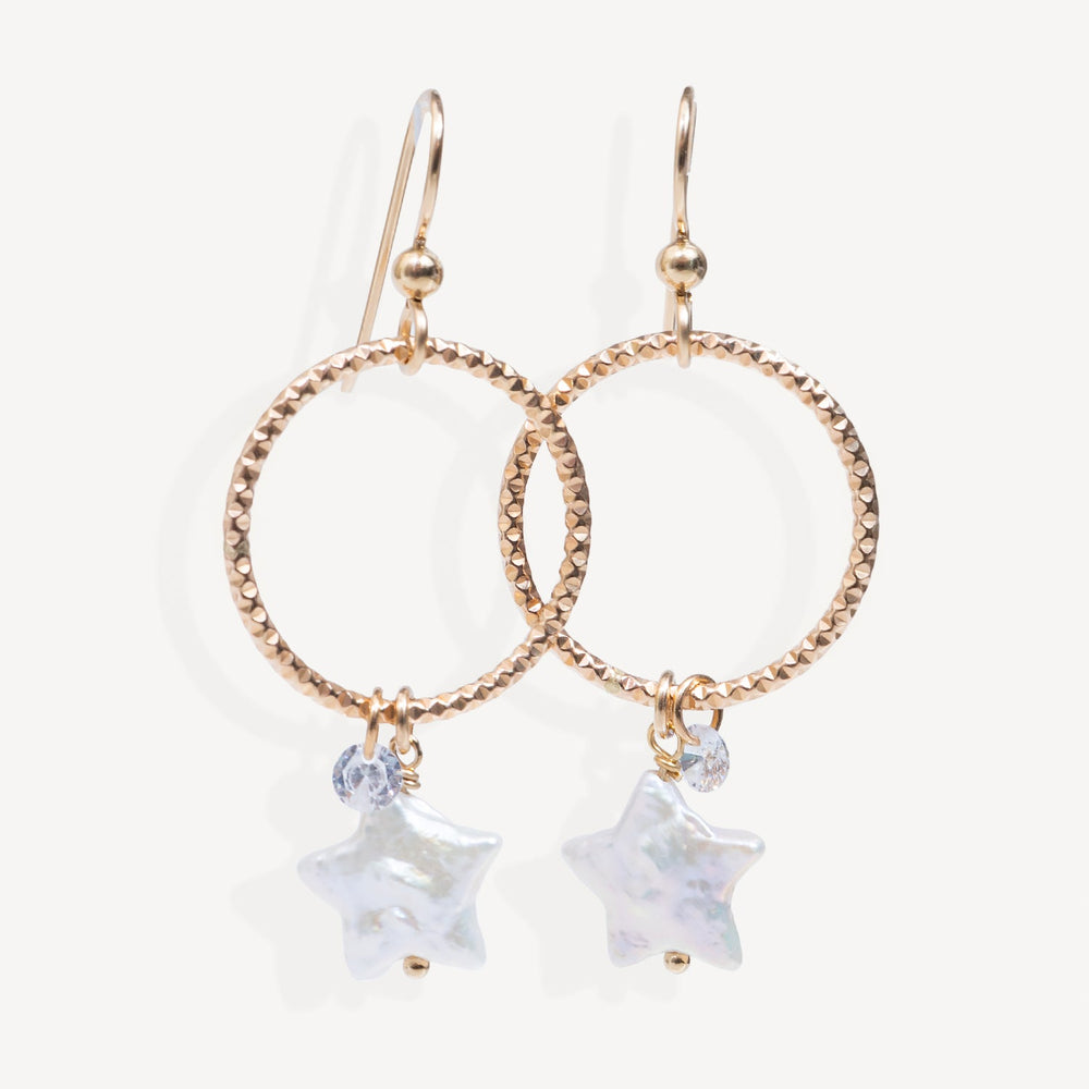 Rose gold hoop earrings with star-shaped charms on a white background