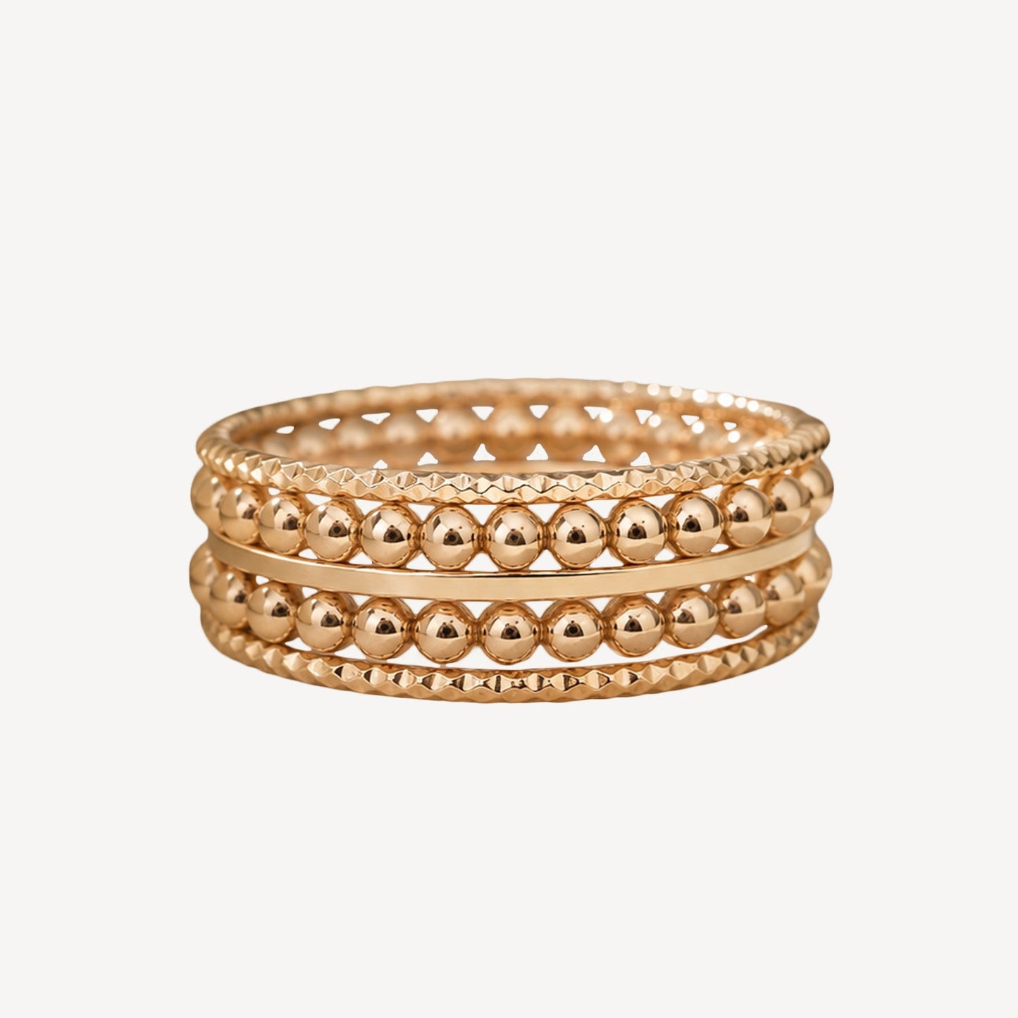 Stack of gold beaded bracelets on a white background