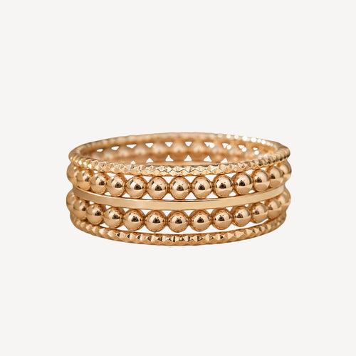Stack of gold beaded bracelets on a white background