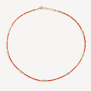 Necklace with red beads and gold chain on a white background