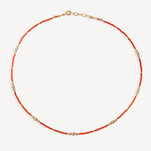Necklace with red beads and gold chain on a white background