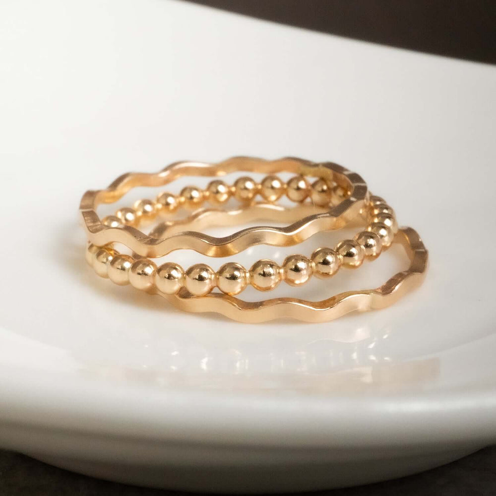Set of gold rings on a light beige background