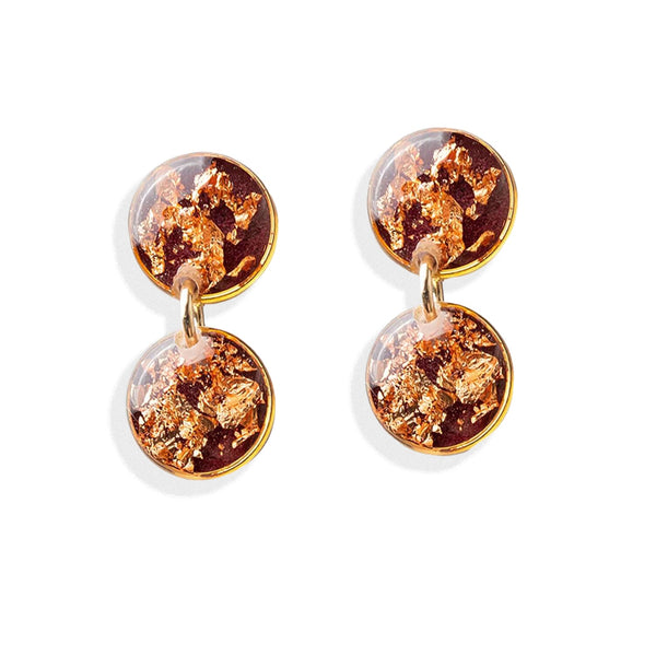 Pair of earrings with gold and brown round stones on a white background