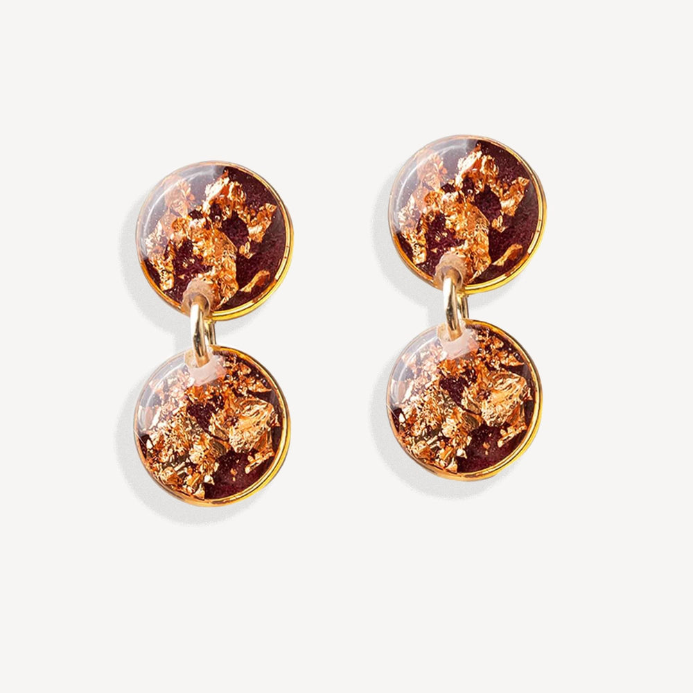 Pair of earrings with gold and copper color scheme on a white background