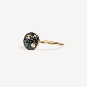 Gold ring with a circular gemstone on a white background