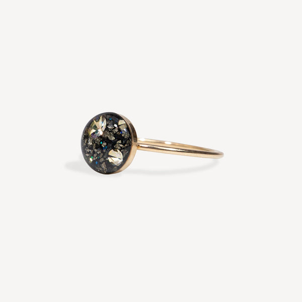 Gold ring with a circular gemstone on a white background