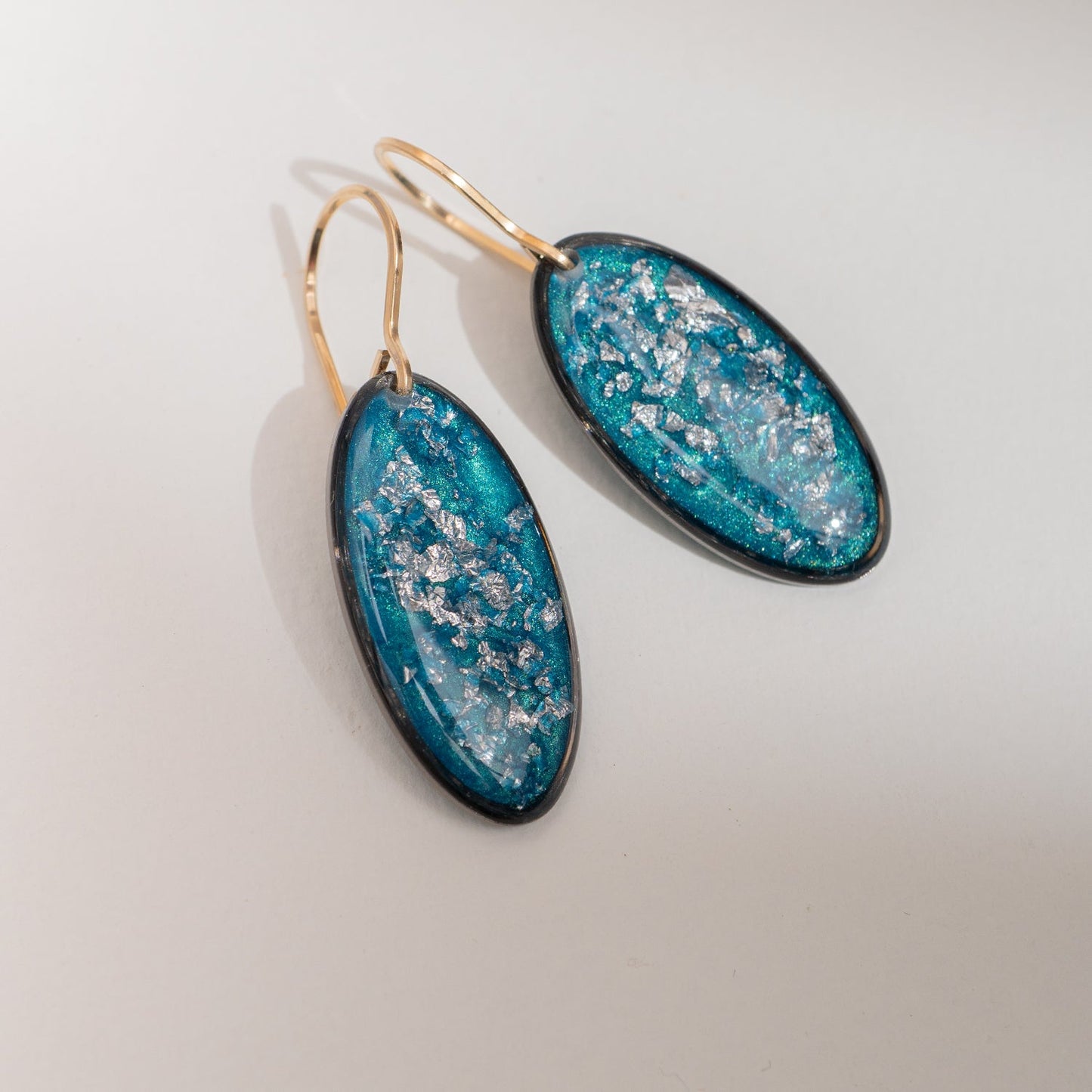 Handcrafted silver glow oval drop earrings with polished silver pendant and textured gold-filled ear wire by Kate Koel