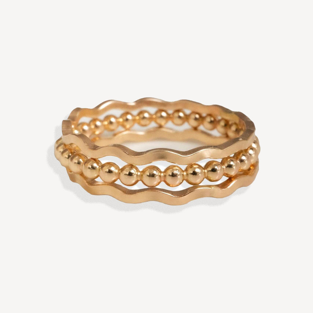 Set of gold rings on a light beige background