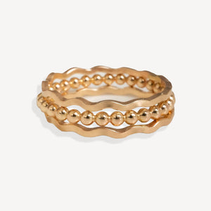 Set of gold rings on a light beige background