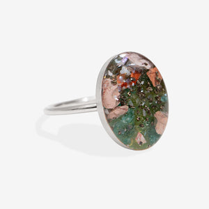 Silver ring with a colorful oval stone on a white background