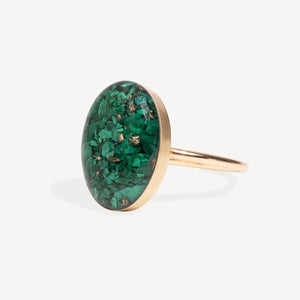 Ring with green stone and gold band on a white background
