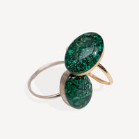 Two green gemstone rings with gold and silver bands on a white background