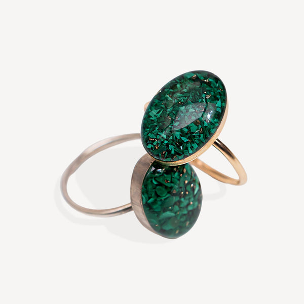 Two green gemstone rings with gold and silver bands on a white background