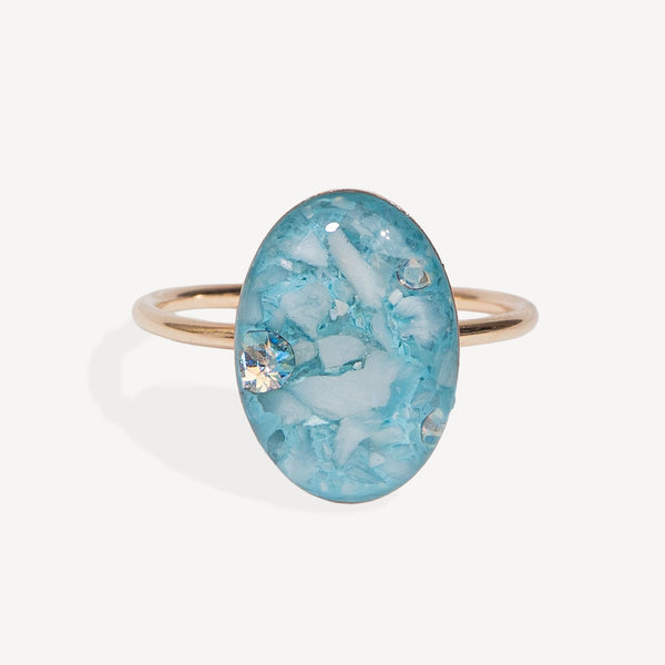 Ring with a blue oval stone on a white background