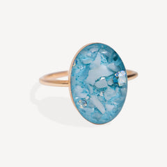 Ring with a blue oval stone on a white background