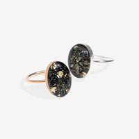 Two rings with black and gold speckled design on a white background