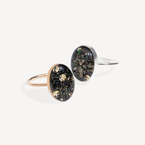 Two rings with black and gold speckled design on a white background