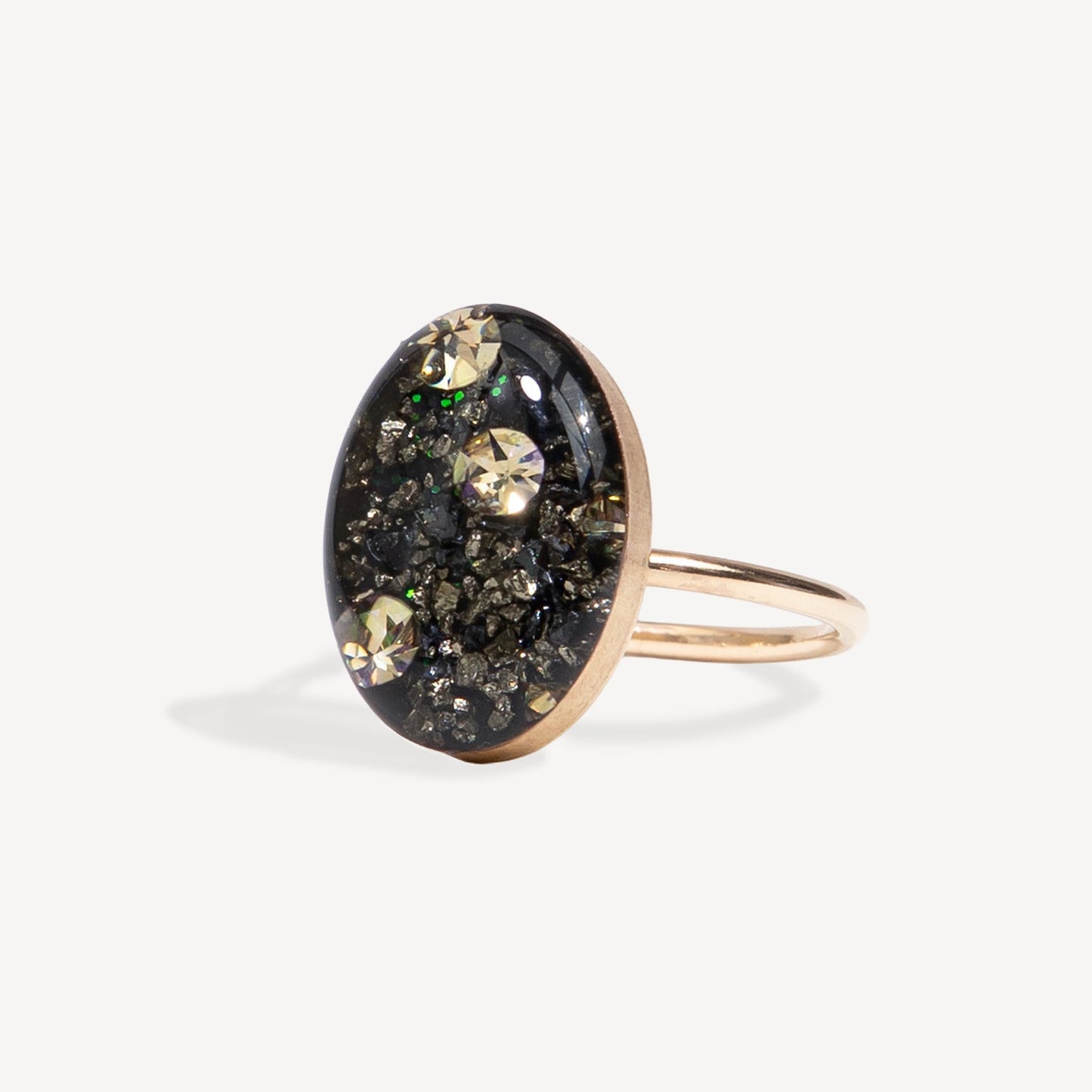 Ring with a black oval stone and gold accents on a white background
