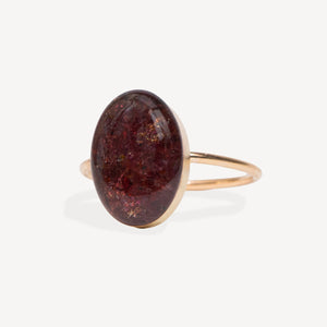 Ring with a large brown oval stone on a white background