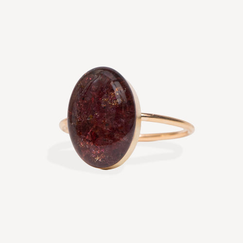 Ring with a large brown oval stone on a white background
