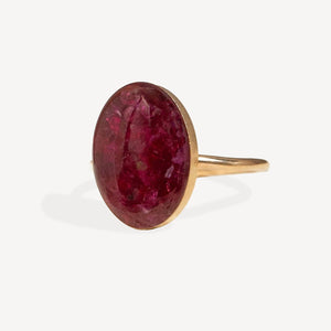 Gold ring with a large red gemstone on a white background