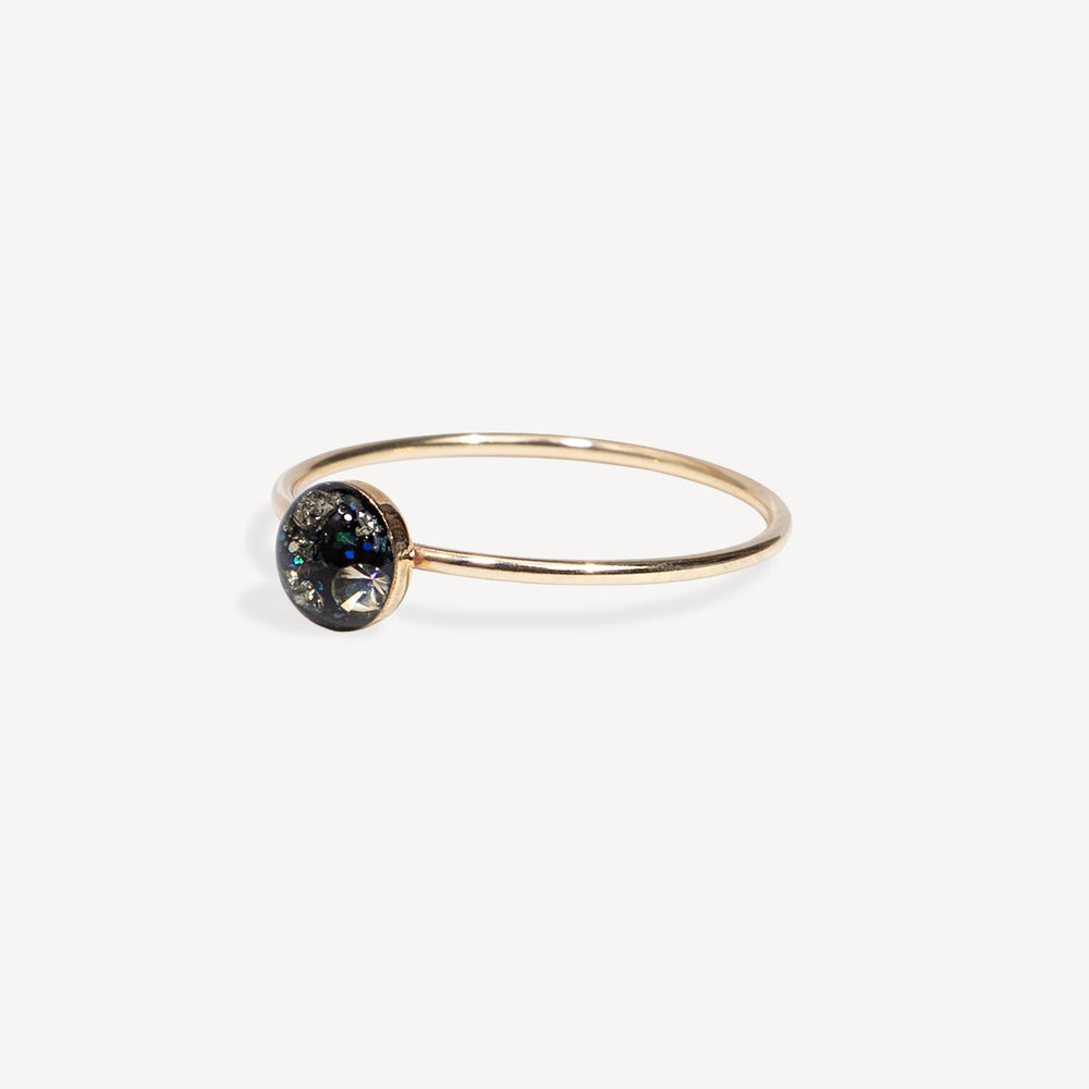 Gold ring with a black gemstone on a white background