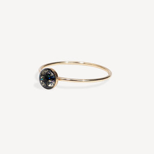 Gold ring with a dark gemstone on a white background