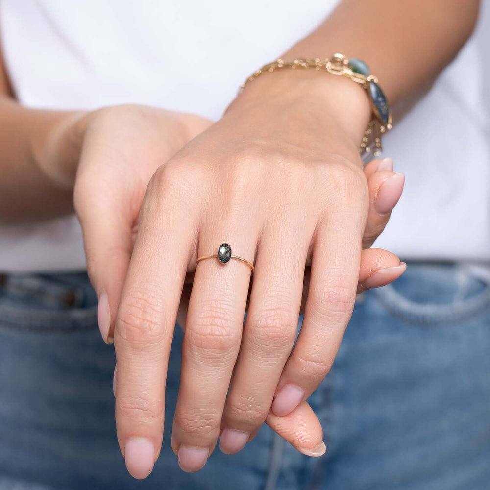 Gold ring with a black gemstone on a white background