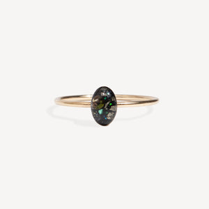 Gold ring with a green gemstone on a white background