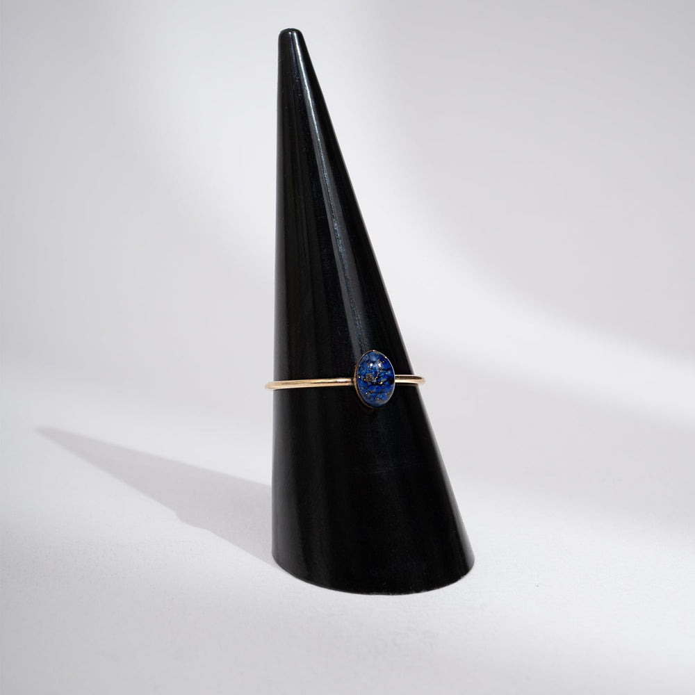 Gold ring with a blue stone on a white background