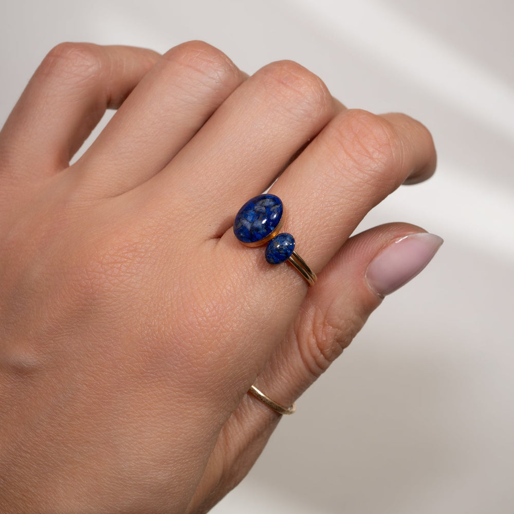 Gold ring with a blue stone on a white background