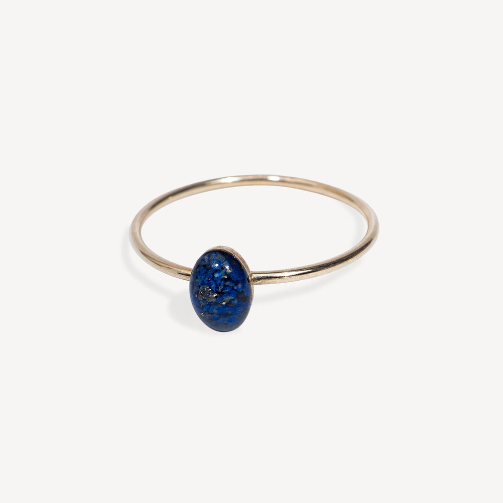 Gold ring with a blue stone on a white background
