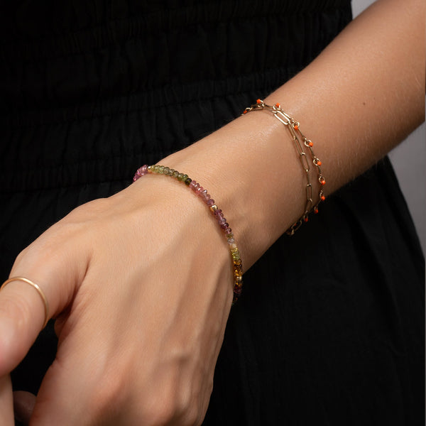 Close-up of a hand wearing a beaded bracelet with a blurred background