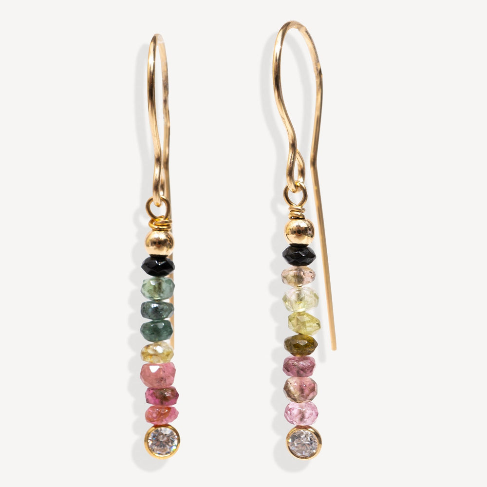 Gold earrings with multicolored gemstones on a white background