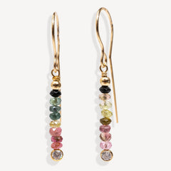 Gold earrings with multicolored gemstones on a white background