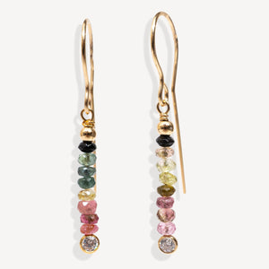 Gold earrings with multicolored gemstones on a white background