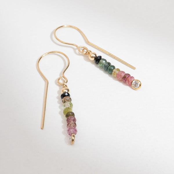 Pair of gold earrings with multicolored beads on a white background
