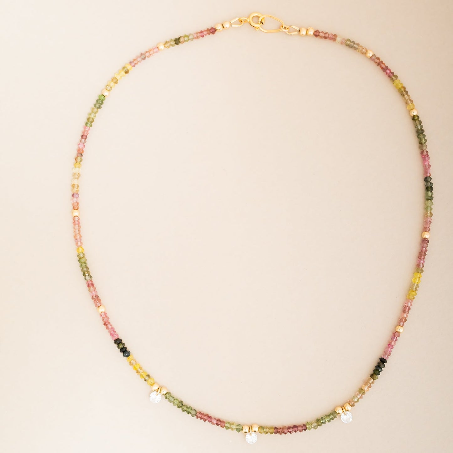 Close-up of faceted watermelon tourmaline beads and cubic zirconia crystal accent on 14k gold filled necklace