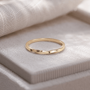 Gold ring on a textured beige surface