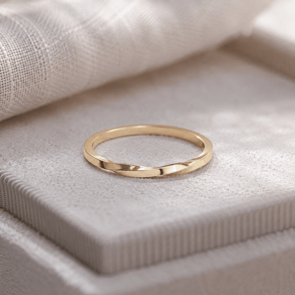 Gold ring on a textured beige surface